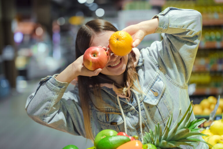 giovane-donna-con-frutta-in-mano-al-supermercato