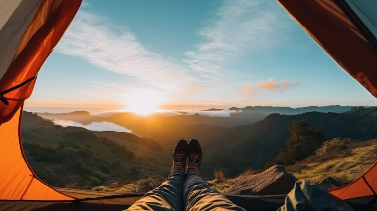 Camper enjoys the mountain view from the comfort of a tent, with